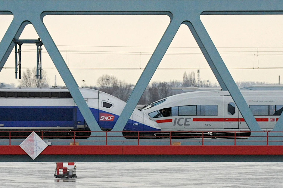 Ein TGV und ein ICE stehen auf einer Rheinbrücke. 