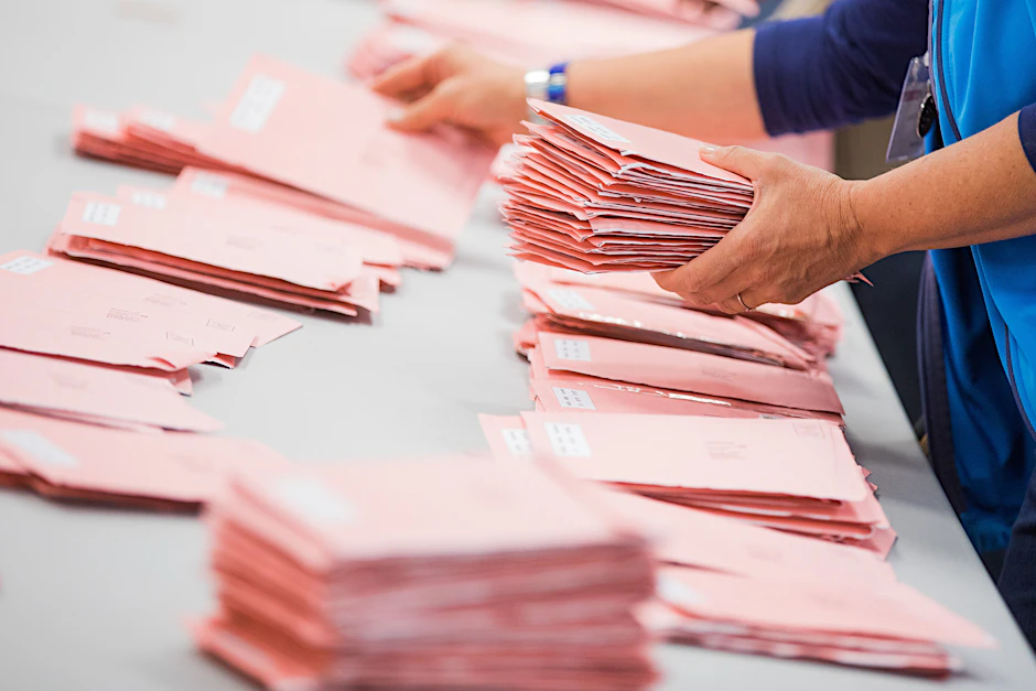 Wahlhelfer sortieren die roten Wahlbriefe mit den abgegebenen Stimmen für die Bundestagswahl (Archivbild).