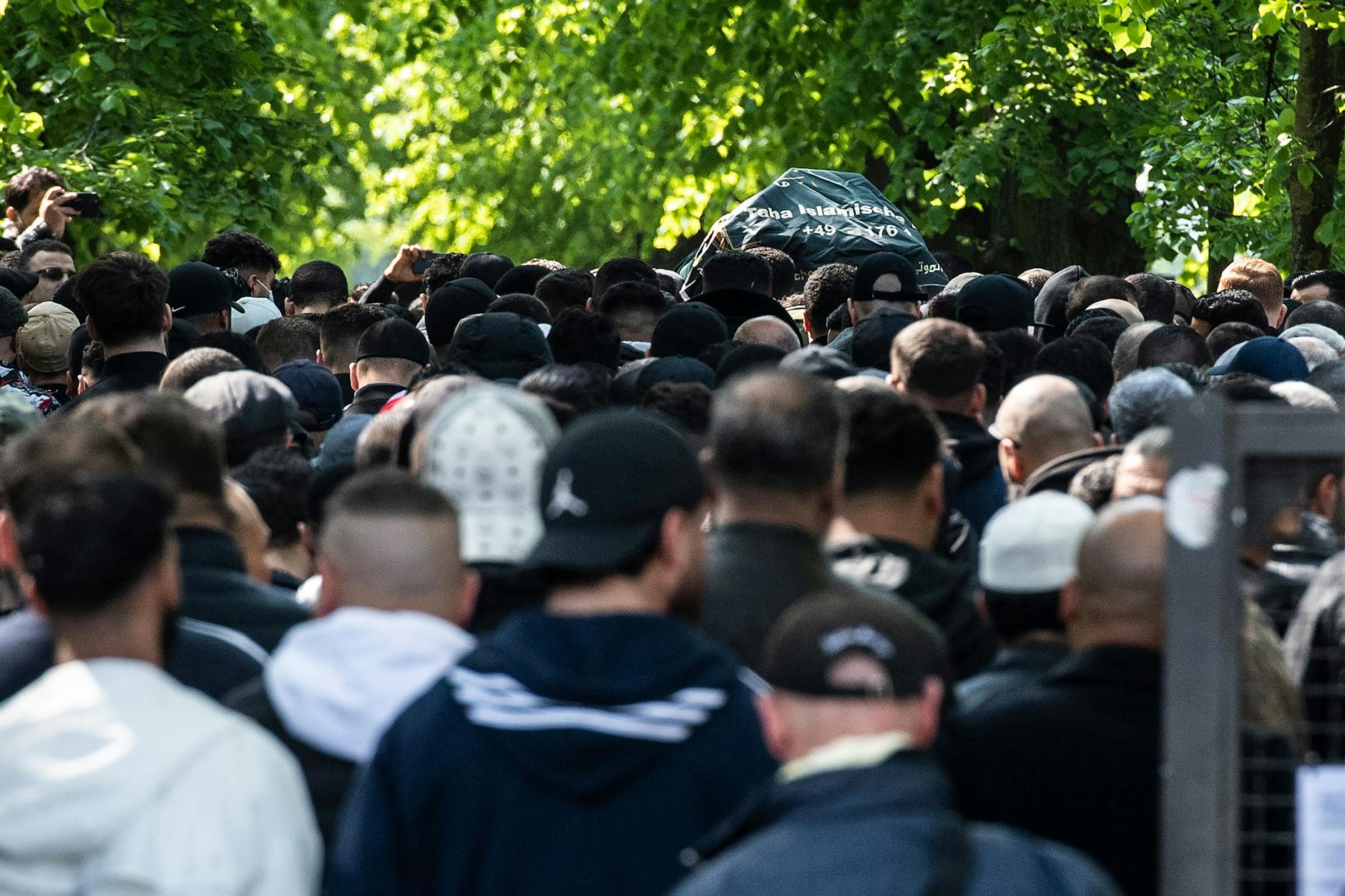 Trauergäste folgen einem Sarg auf einer Beerdigung.