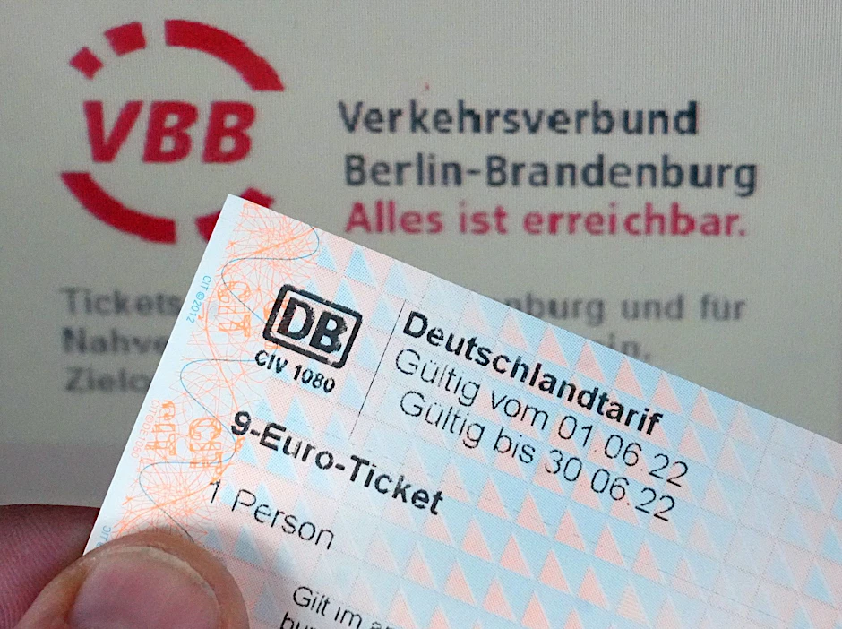 Ein Glücklicher hält auf dem Potsdamer Hauptbahnhof ein 9-Euro-Ticket vor einem Ticketautomaten.