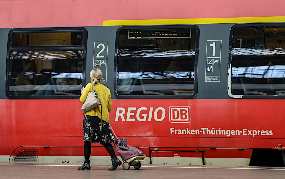 Eine Frau geht an einem Regionalexpress entlang.