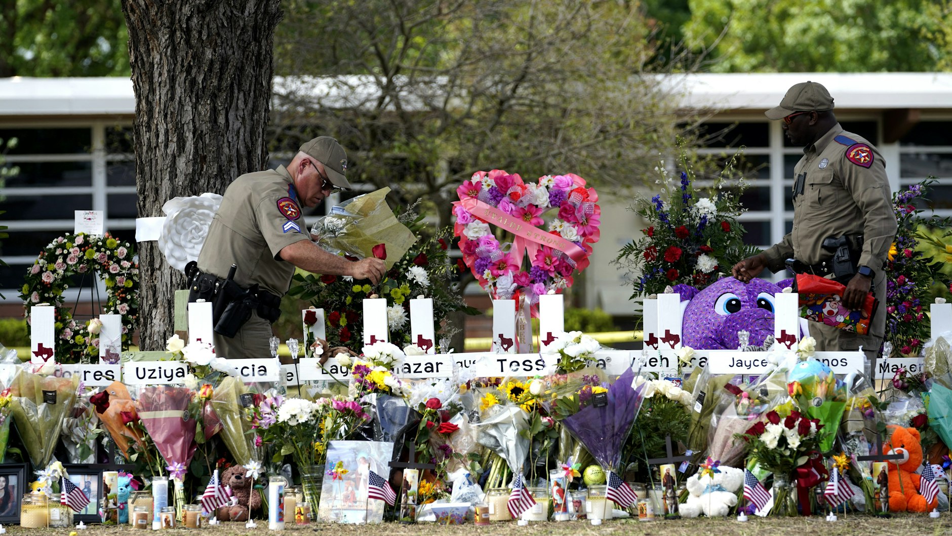 Polizeibeamte legen Blumen vor der Robb Elementary School in der Stadt Uvalde, Texas, USA nieder. Mindestens 19 Kinder und zwei Erwachsene wurden am Dienstag bei einer Schießerei in der Robb-Grundschule getötet.