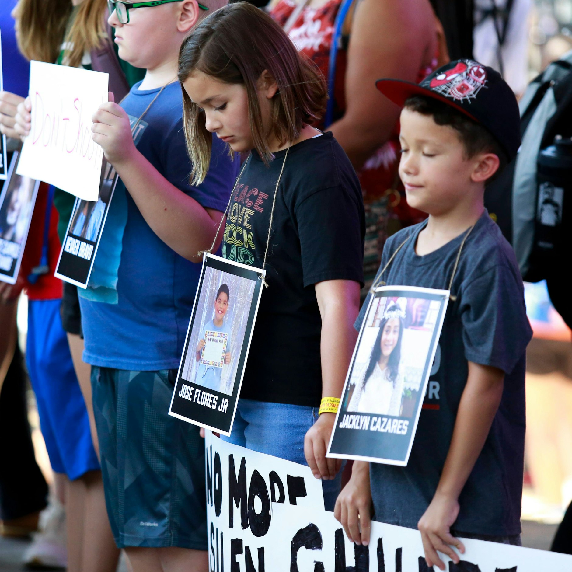 Kinder tragen die Fotos der getöteten Schulkinder vor der Brust, um gegen die Waffengesetze zu demonstrieren.