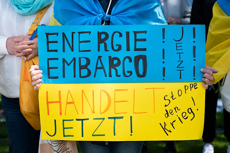 Bei einer Kundgebung für den Beitritt der Ukraine in die EU hält eine Demonstrantin ein Plakat mit der Aufschrift „Energie Embargo - Handelt Jetzt!“.
