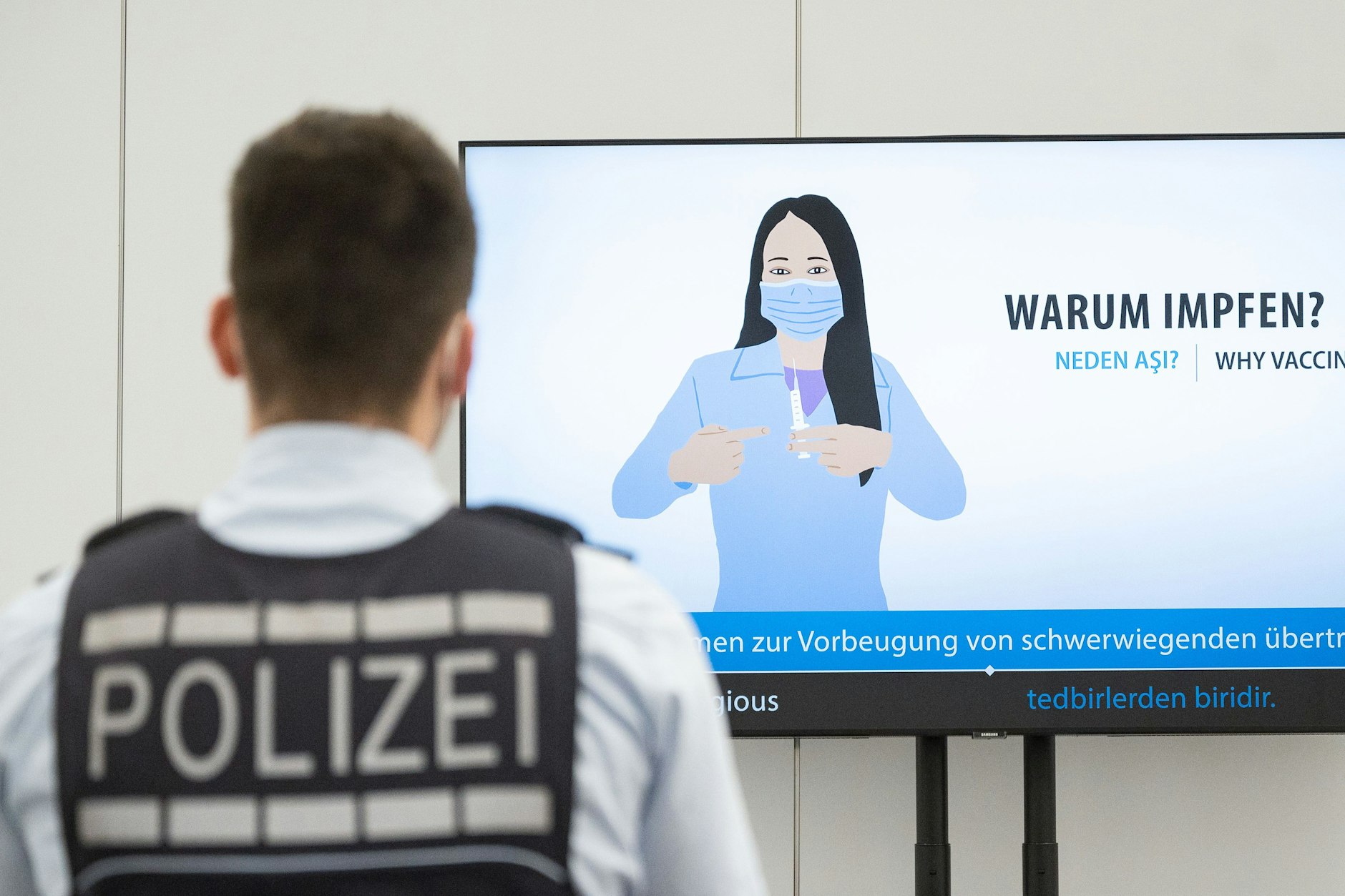 Ein Polizeibeamter in einem Impfzentrum. Oft müssen sich die Beamten dort auch mit Straftaten auseinandersetzen.