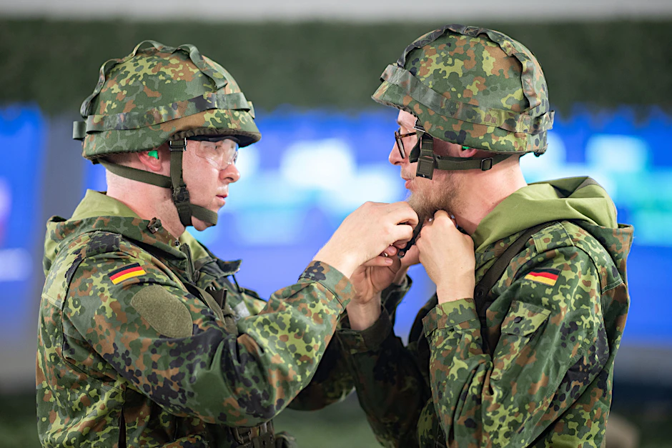 Manchmal hapert es auch bei den einfachsten Ausrüstungsgegenständen. Hier hilft ein Soldat seinem Kameraden den Helm zu schließen. Die Bundeswehr soll modernisiert werden – das Verfahren der Beschaffung aber auch.