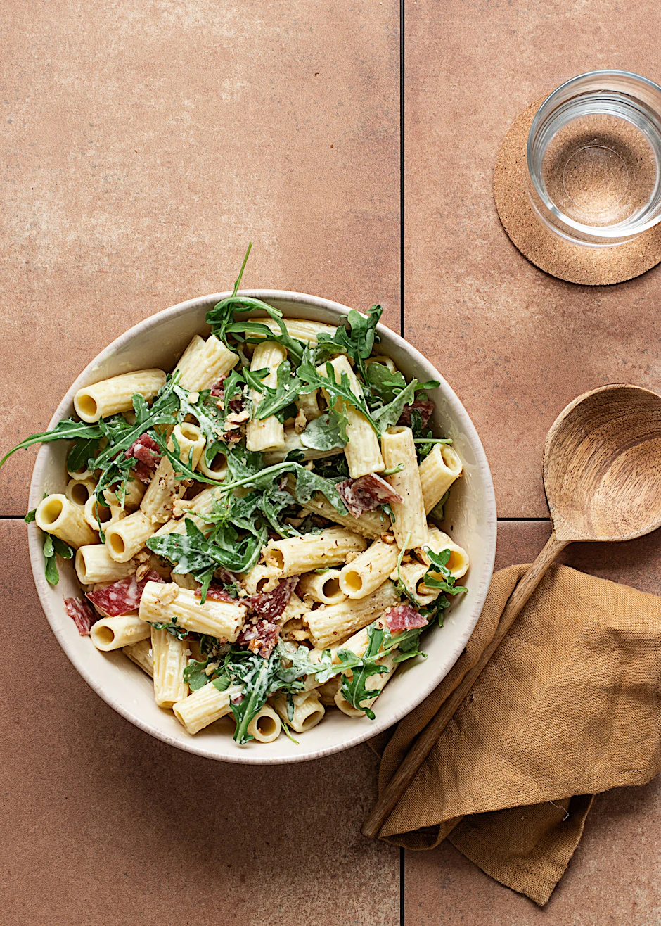 Dieser Nudelsalat mit Salami, Rucola und Nüssen ist einfach köstlich - das Rezept bringt Abwechslung aufs Grill-Buffet.