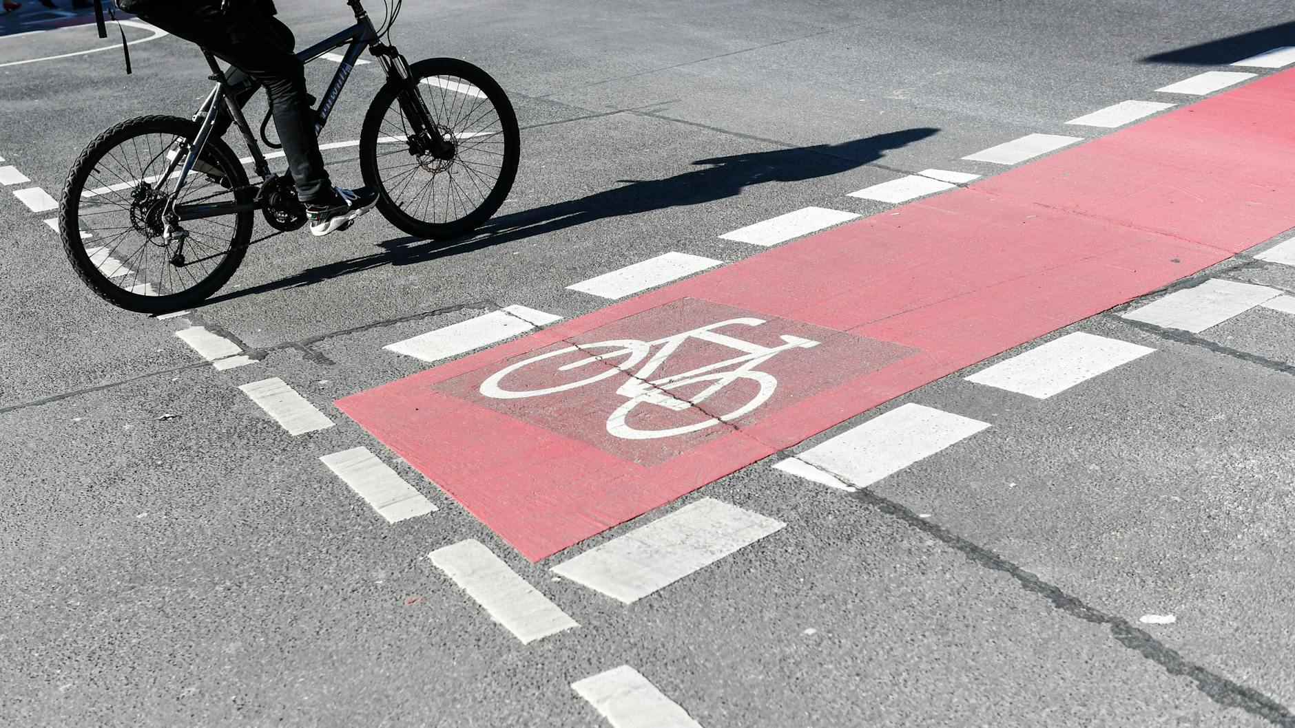 Berlin: Ein Radfahrer fährt auf einer Straße neben einem rot markierten Radweg. Ist das erlaubt?