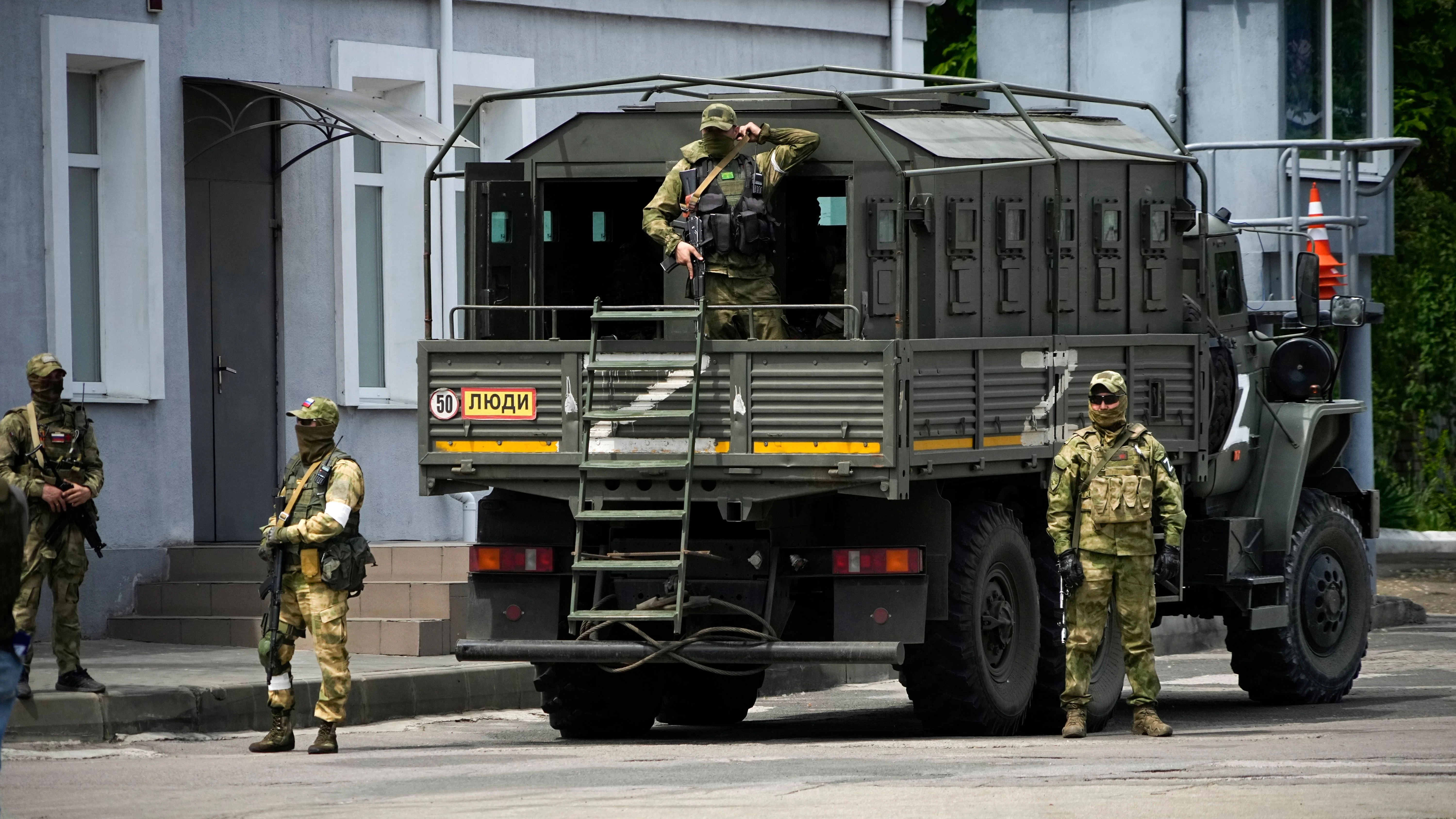 Russische Soldaten bewachen eine organisierte Pressereise in der besetzten Stadt Cherson in der Ukraine. Das Buch weist erschreckende Parallelen zur russischen Invasion der Ukraine auf.