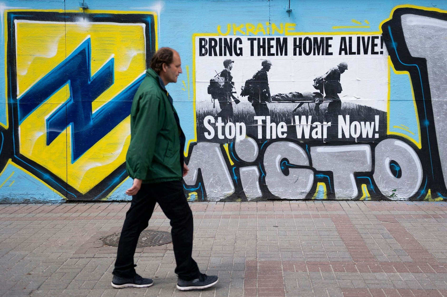 Ein Mann geht in Kiew an einem Poster vorbei, das zur Unterstützung der Verteidiger von Mariupol angebracht wurde.  