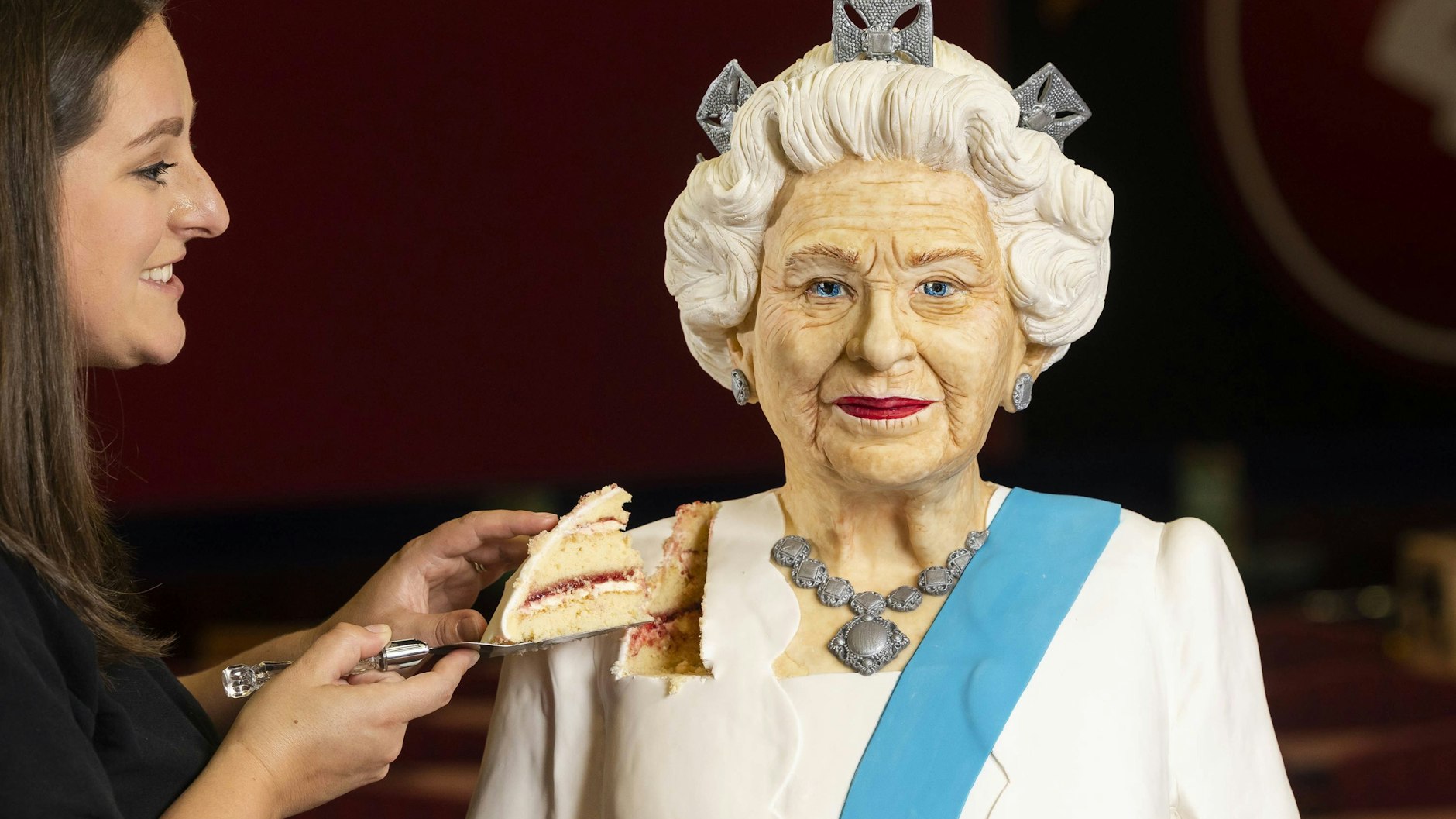 Die Queen als Torte: Bäckerin Lara Mason enthüllt die lebensgroße Figur von Königin Elisabeth II. zur Feier des Platinjubiläums im Buzz Bingo.