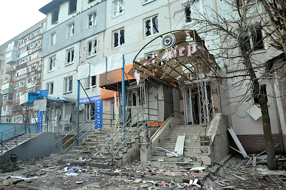 Blick auf Geschäfte im Erdgeschoss und ein Wohnhaus in Sjewjerodonezk, die durch den Beschuss durch russische Truppen beschädigt wurden.