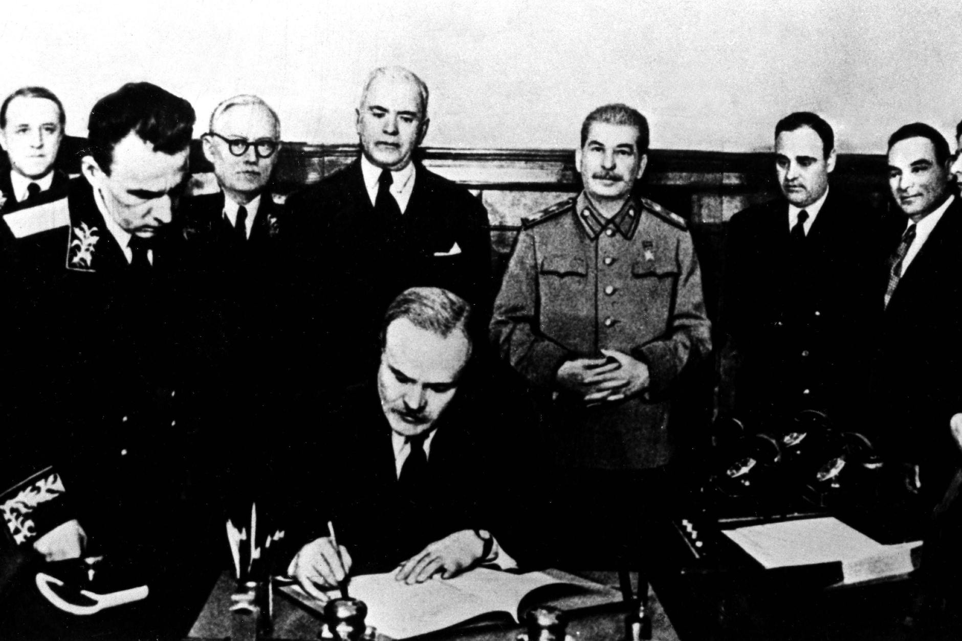 Der sowjetische Außenminister Wjatscheslaw Molotow bei der Ratifizierung des deutsch-russischen Nichtangriffspakts. Hinter ihm, Joachim von Ribbentrop und Josef Stalin, 1939.