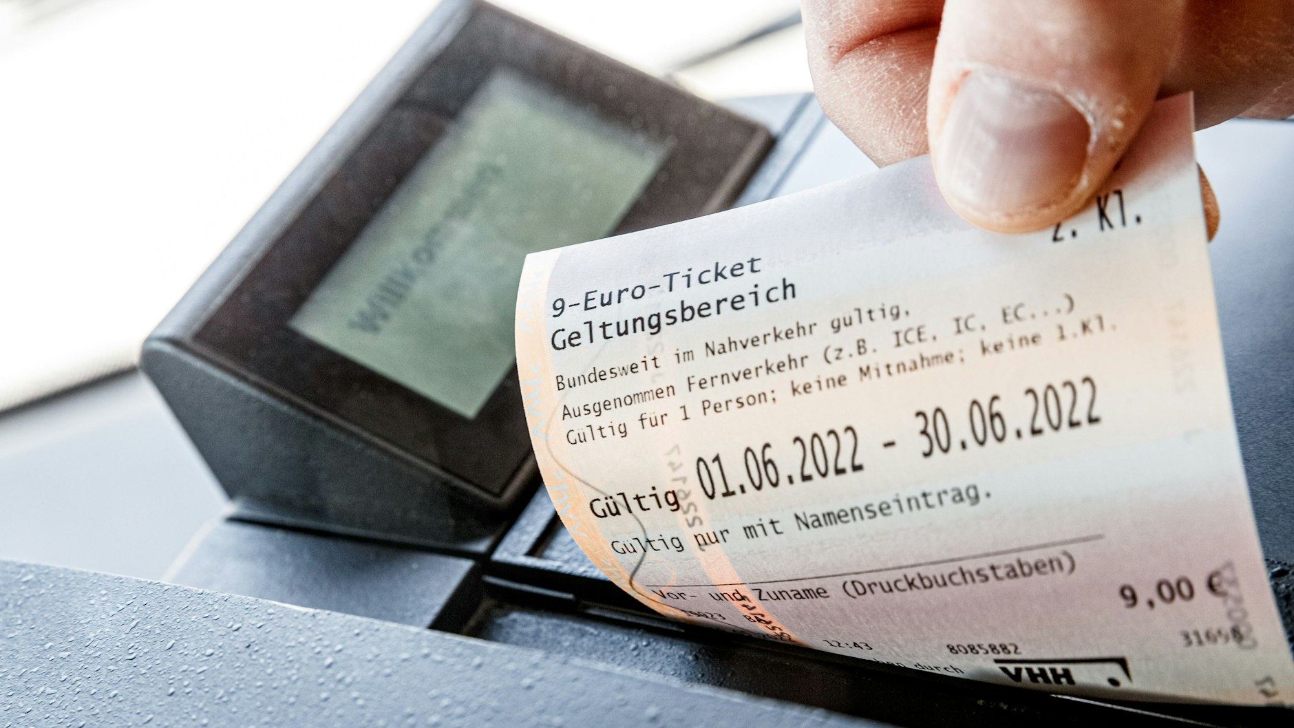 Ein Kunde zieht in einem Bus der VHH ein 9-Euro-Ticket aus dem Fahrkartendrucker.