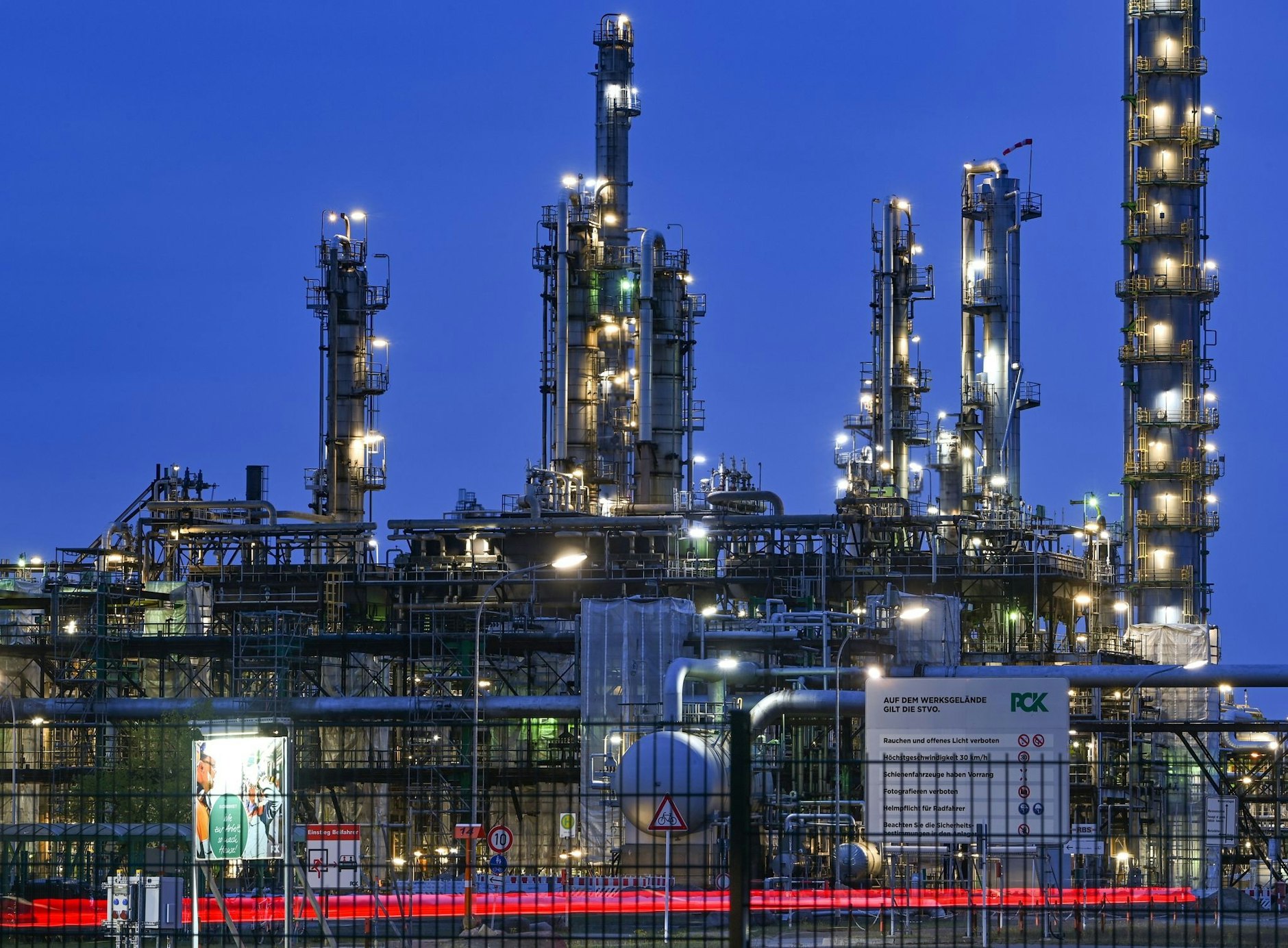 ARCHIV - Die Anlagen der Erdölraffinerie auf dem Industriegelände der PCK-Raffinerie GmbH sind abends beleuchtet.  