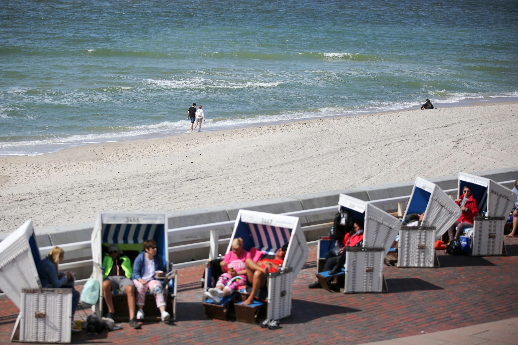 Besucher genießen die Sonne am Strand in Westerland auf Sylt. Mit dem Start des 9-Euro-Tickets werden viele Urlauber auf der Insel erwartet.  