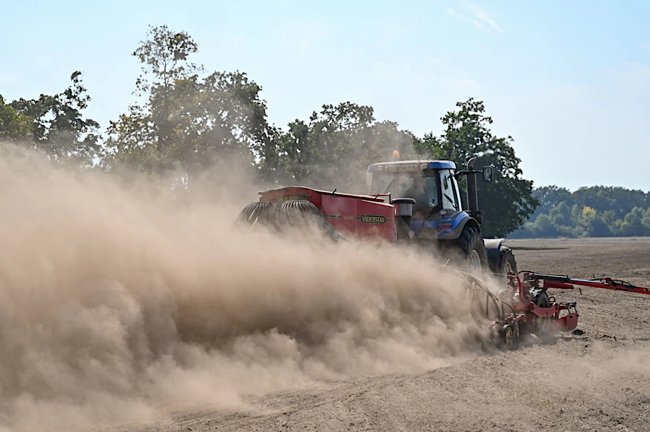 ARCHIV - Ein Landwirt fährt mit einem Traktor und angehängter Drille über ein Feld.  a/Archivbild