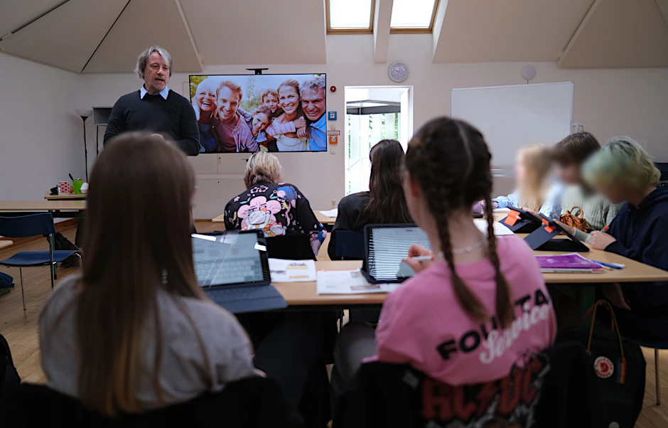 Die neue Willkommensklasse am Canisius-Kolleg: Jan Gursch-Büdenbender fragt seine ukrainischen Schüler, wie die Personen auf dem großen Familienfoto heißen.