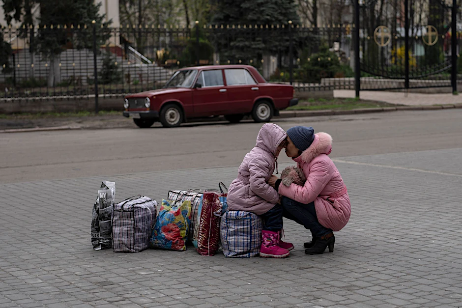 Eine Mutter wartet mit ihrer Tochter auf einen Bus, um aus der Stadt Slowjansk im Nordwesten der Ukraine zu fliehen.