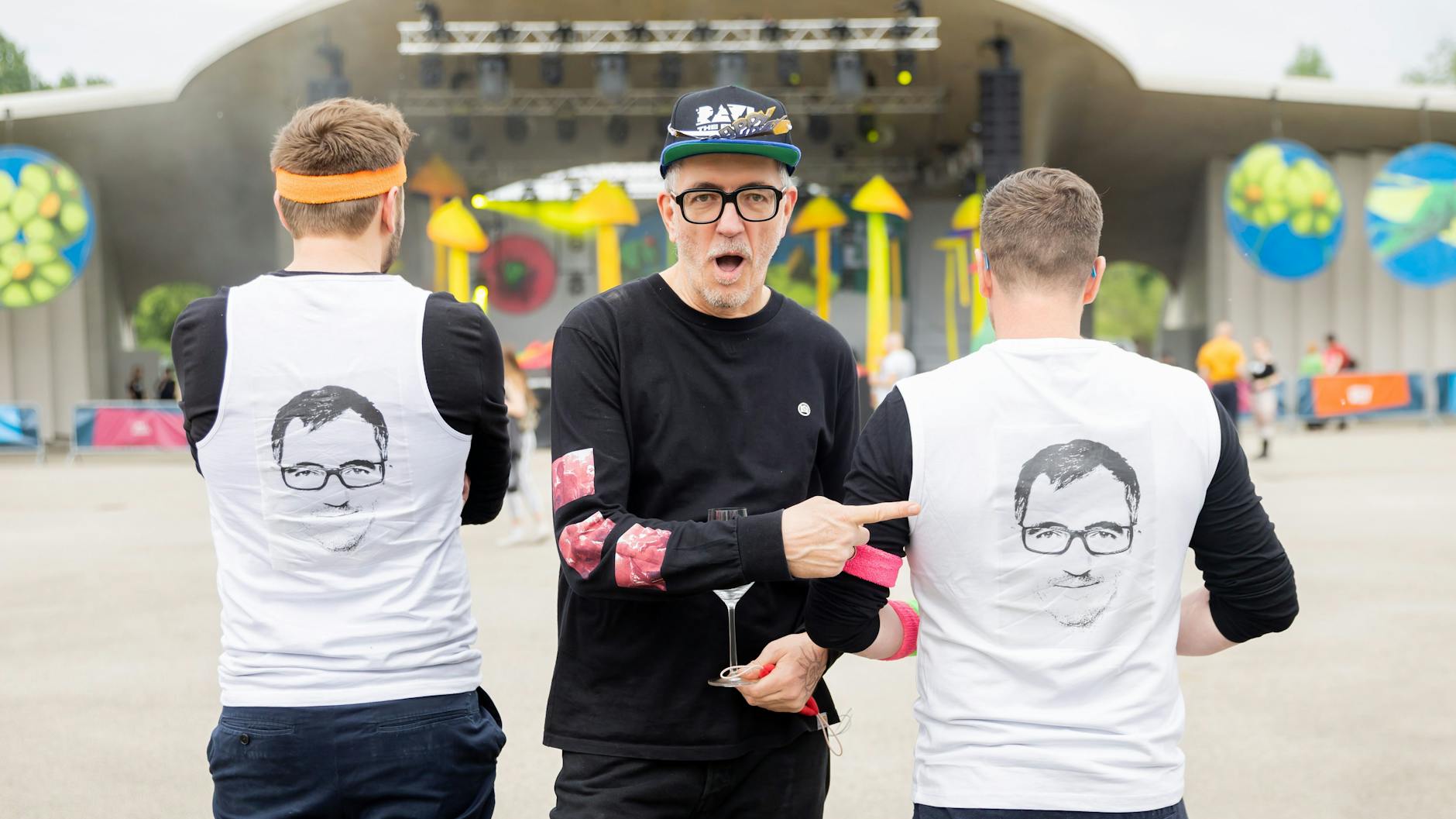 Dr. Motte steht beim Open-Air-Rave „Dr. Motte’s Birthday Celebration 2 x 30“ in den Gärten der Welt neben zwei seiner Fans.