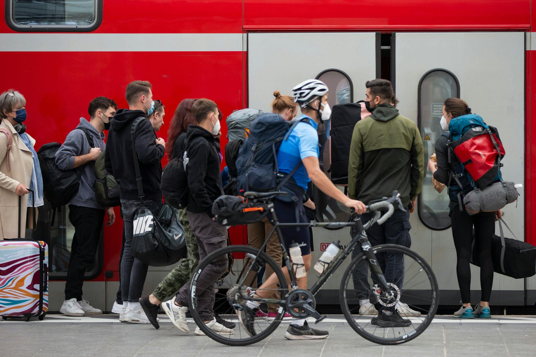 Fahrgäste warten an einem Regionalzug.