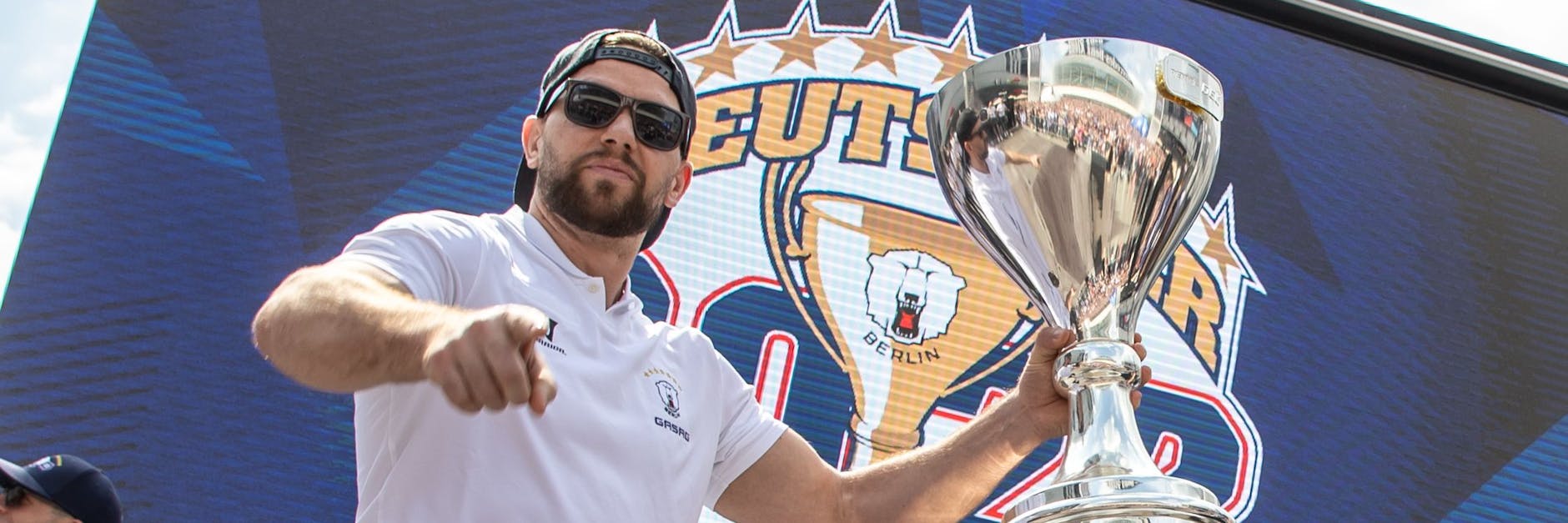 Cool, cooler, Matt White. Der US-Boy posiert mit dem Meisterpokal der Eisbären für die Kamera.