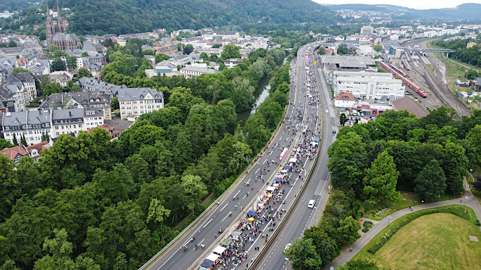 Fußgänger und Fahrräder statt Autos: Tausende Menschen strömen zu «Tischlein deck dich» auf die als «Stadtautobahn» bekannte B3 in Marburg.  dpa