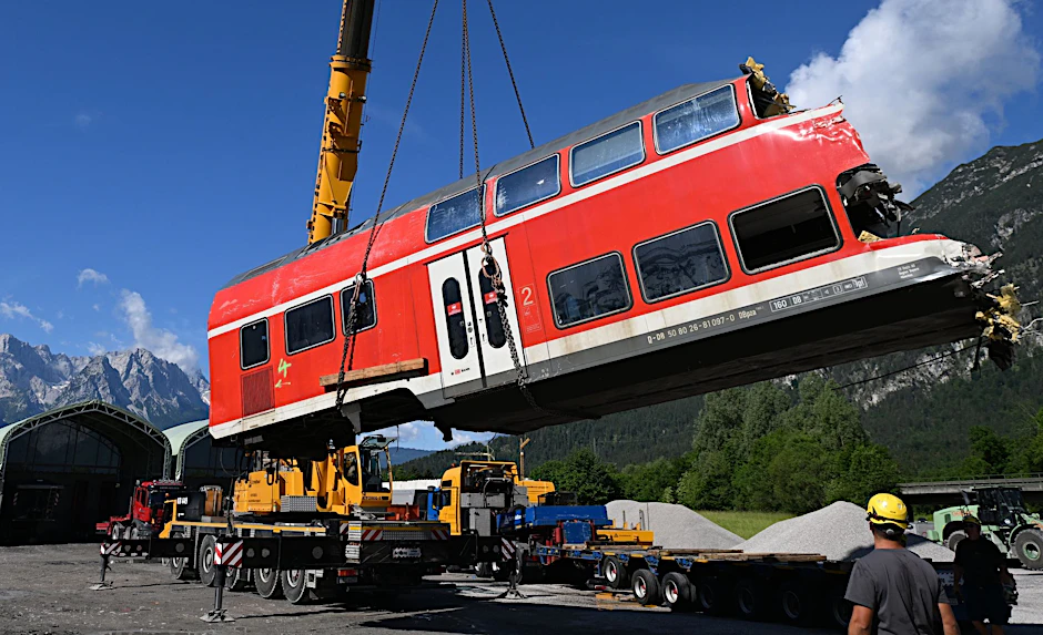 Nach dem Zugunglück von Garmisch-Partenkirchen gehen die Aufräumarbeiten voran. Ein auseinandergeschnittenes Waggonteil wird von einem Laster gehoben.