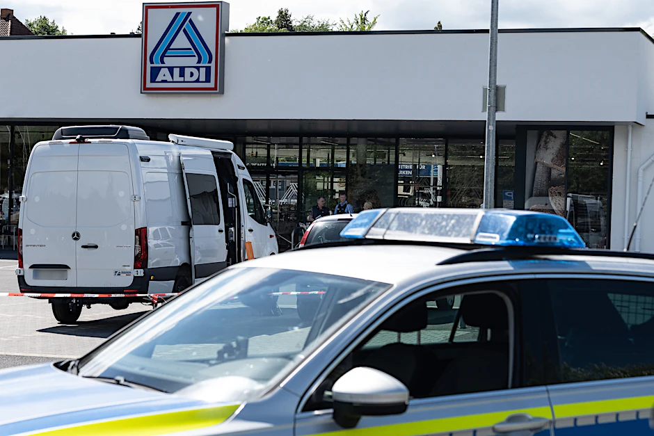 Schwalmstadt: Einsatzfahrzeuge der Polizei stehen vor dem abgesperrten Einkaufsmarkt.