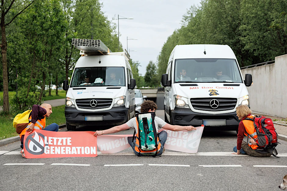 Aktivisten der Gruppierung Letzte Generation blockieren eine Straße.