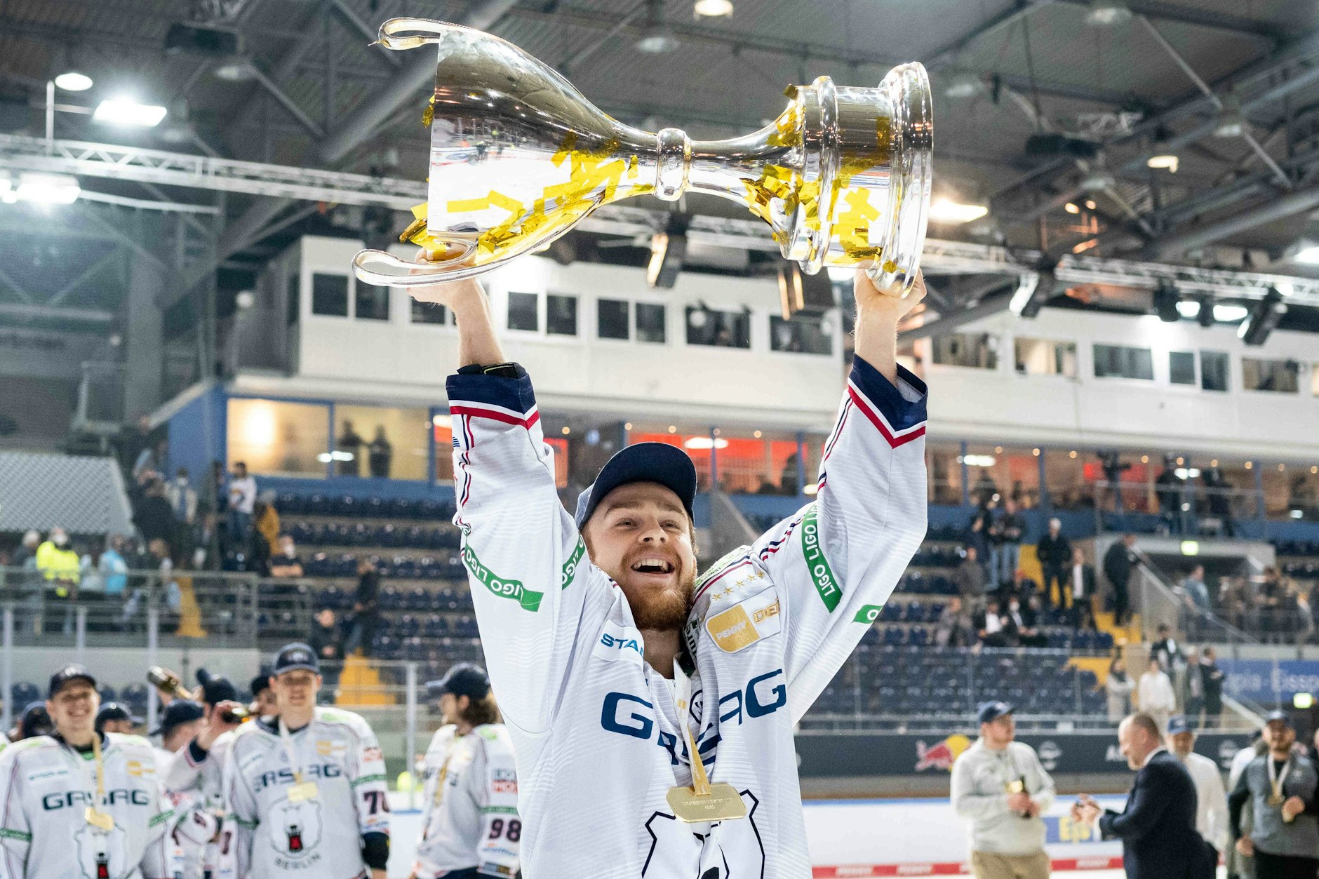 Marco Baßler stemmt seinen ersten Meisterpokal in de Höhe.