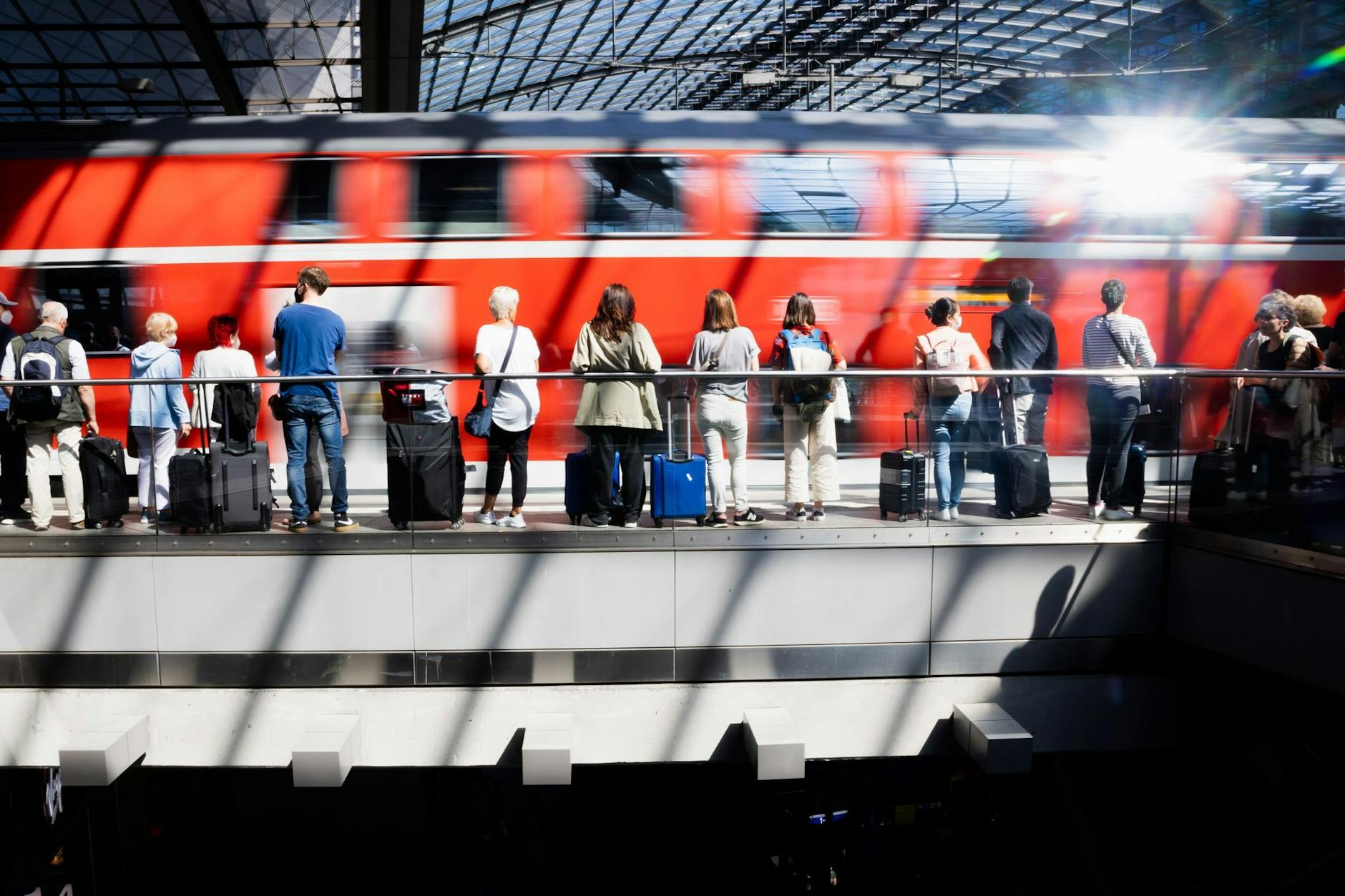 Fahrgäste warten am Berliner Hauptbahnhof auf die Einfahrt eines Regionalexpresses.