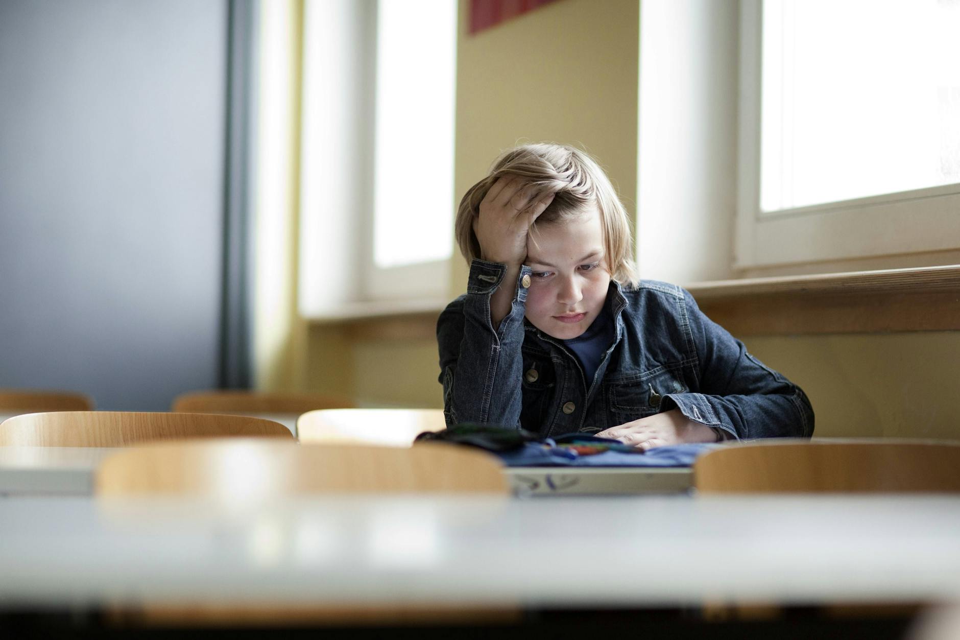 Zwischen Wunsch und Wirklichkeit: Ein Schüler sitzt allein in seinem Klassenzimmer.