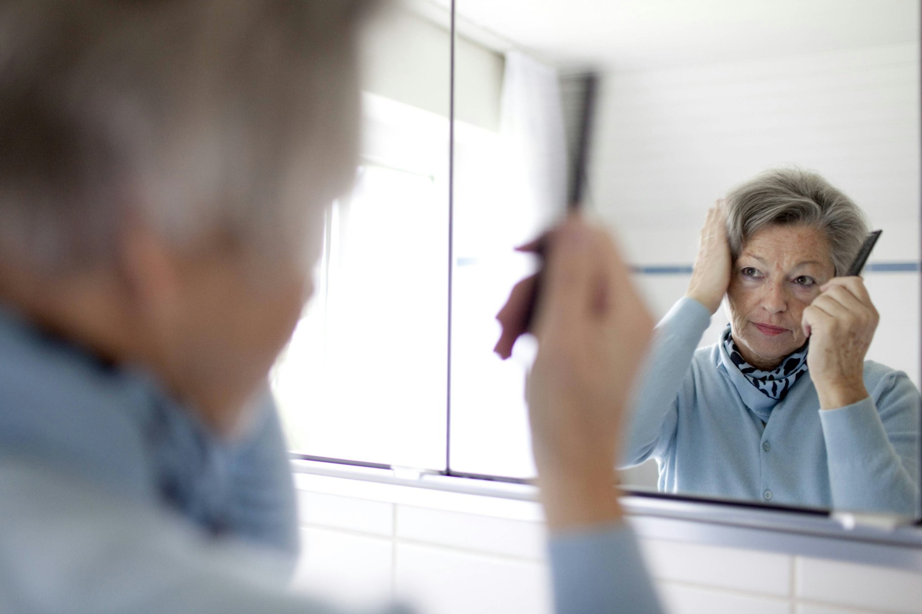 Kritischer Blick in den Spiegel: Ausfallende Haare werden offensichtlich, wenn die Kopfhaut durchscheint.
