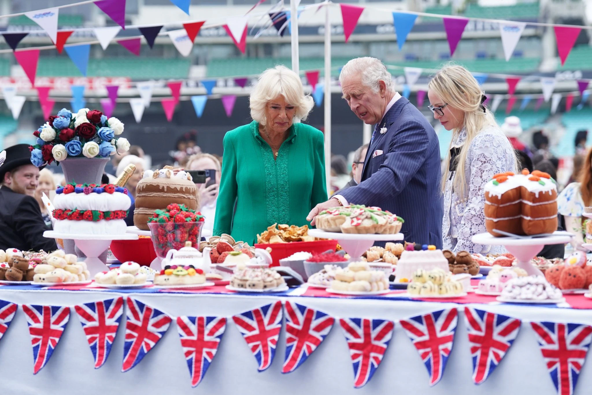 Charles (l), Prinz von Wales, und Camilla, Herzogin von Cornwall, begutachten das Kuchenbuffet.  