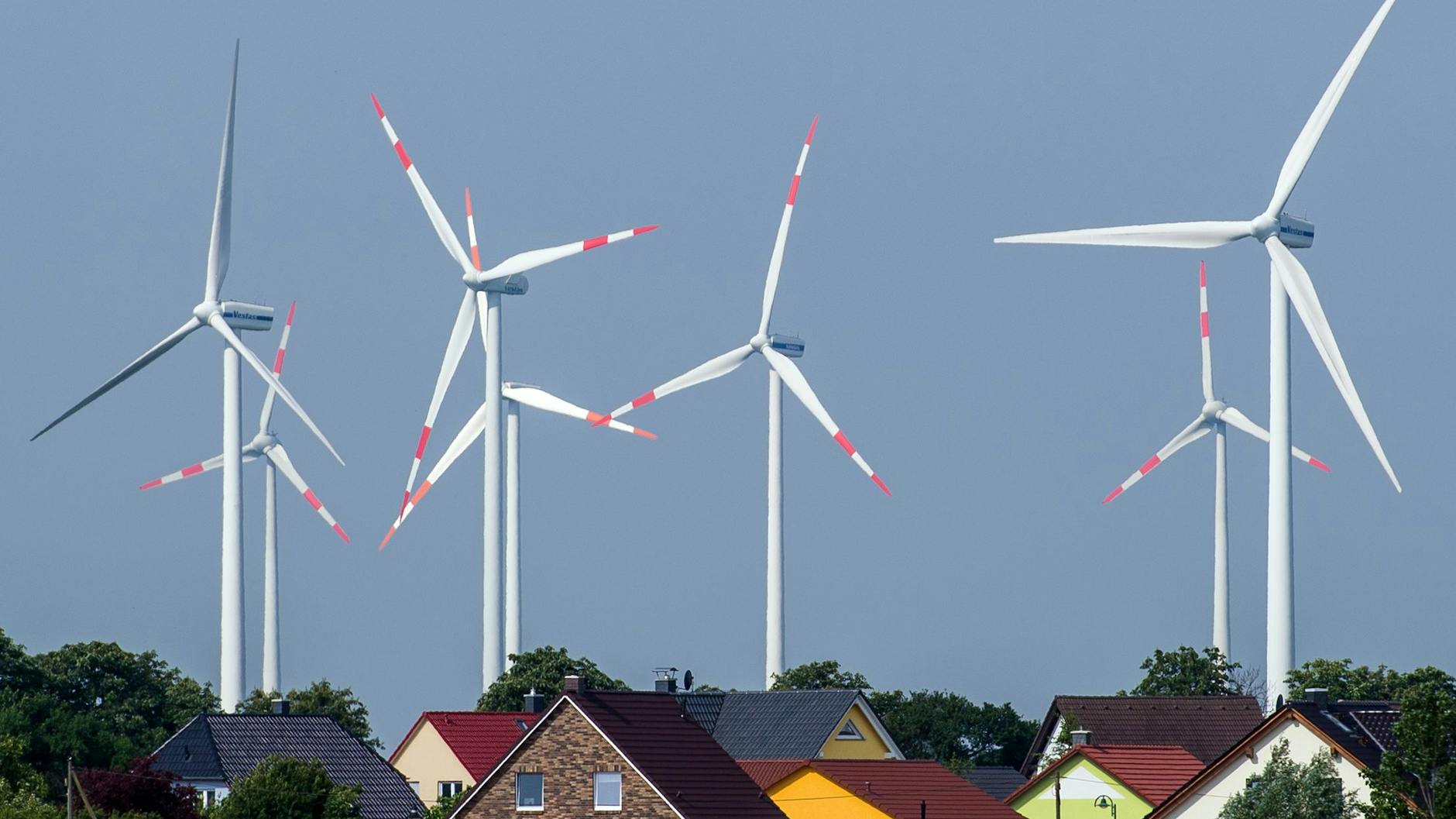 Windräder eines Windenergieparks hinter Einfamilienhäusern nahe Nauen (Brandenburg)