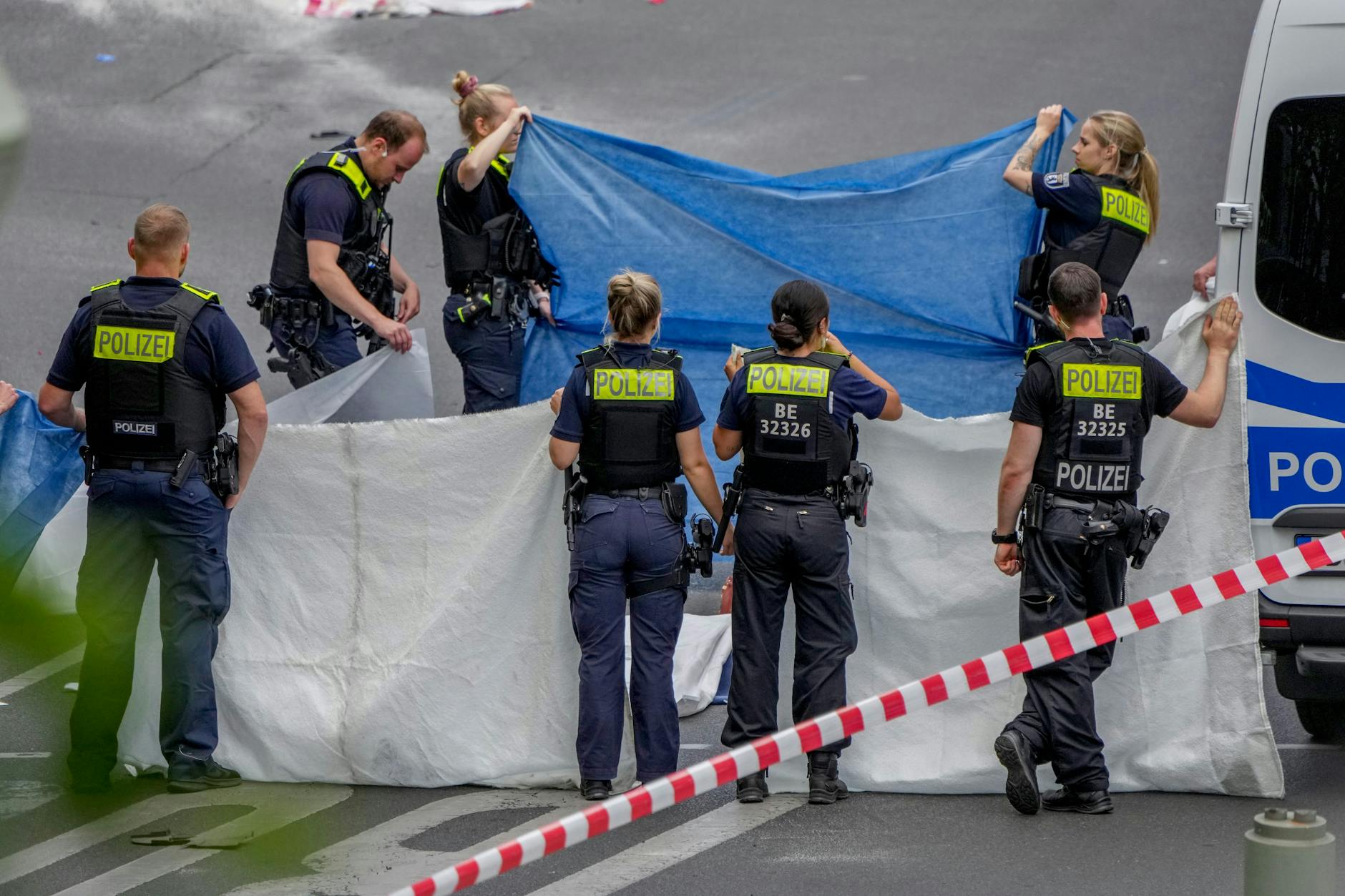 Schreckliches Bild: Hier starb die Lehrerin der Schulklasse aus Hessen. Polizisten schützen den Leichnam vor den Blicken der Passanten mit einer Plane.