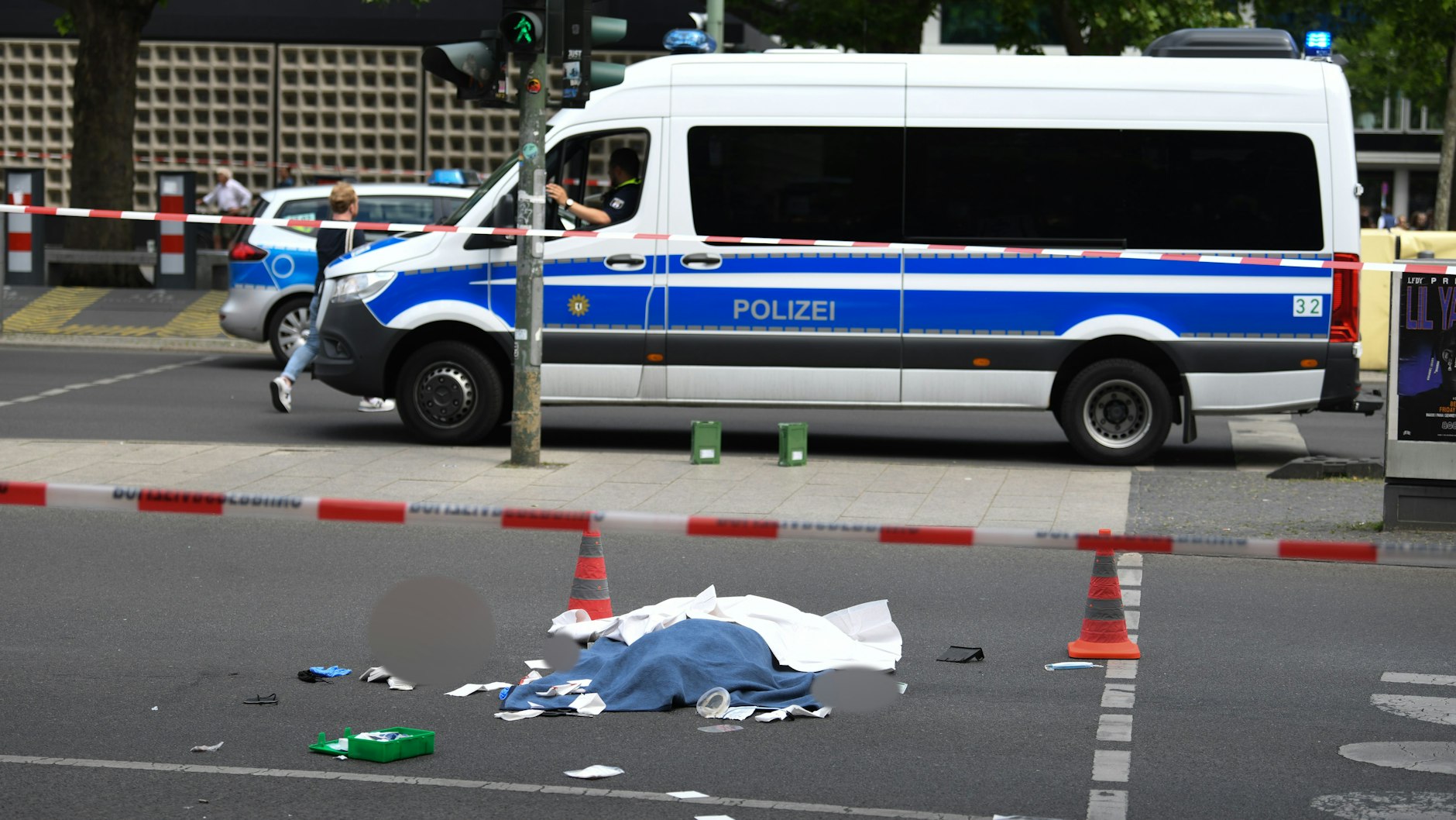 Das Todesopfer liegt abgedeckt auf der Straße. 