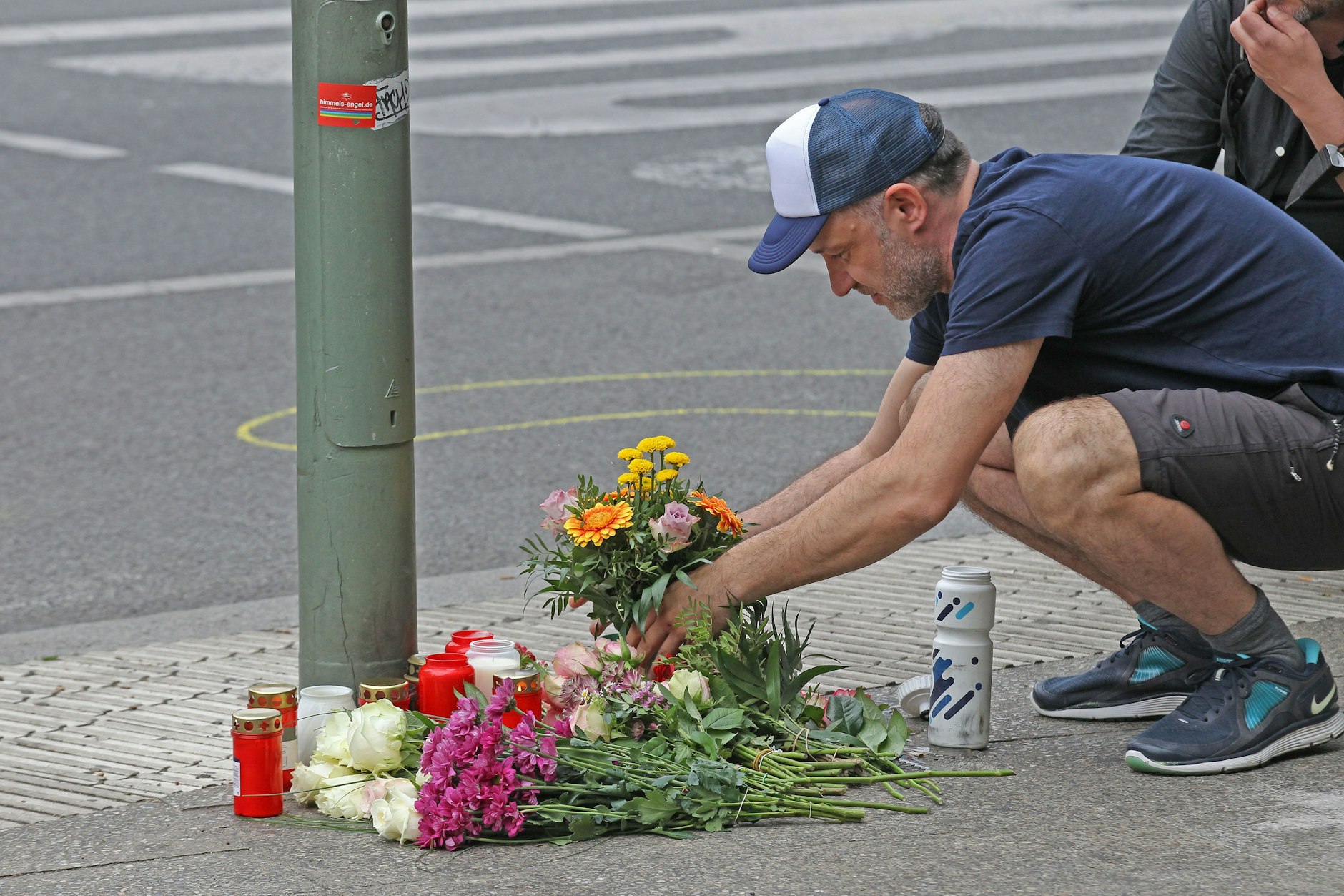 Physiotherapeut Paul legt Blumen an der Ecke Ranke- und Tauentzienstraße nieder