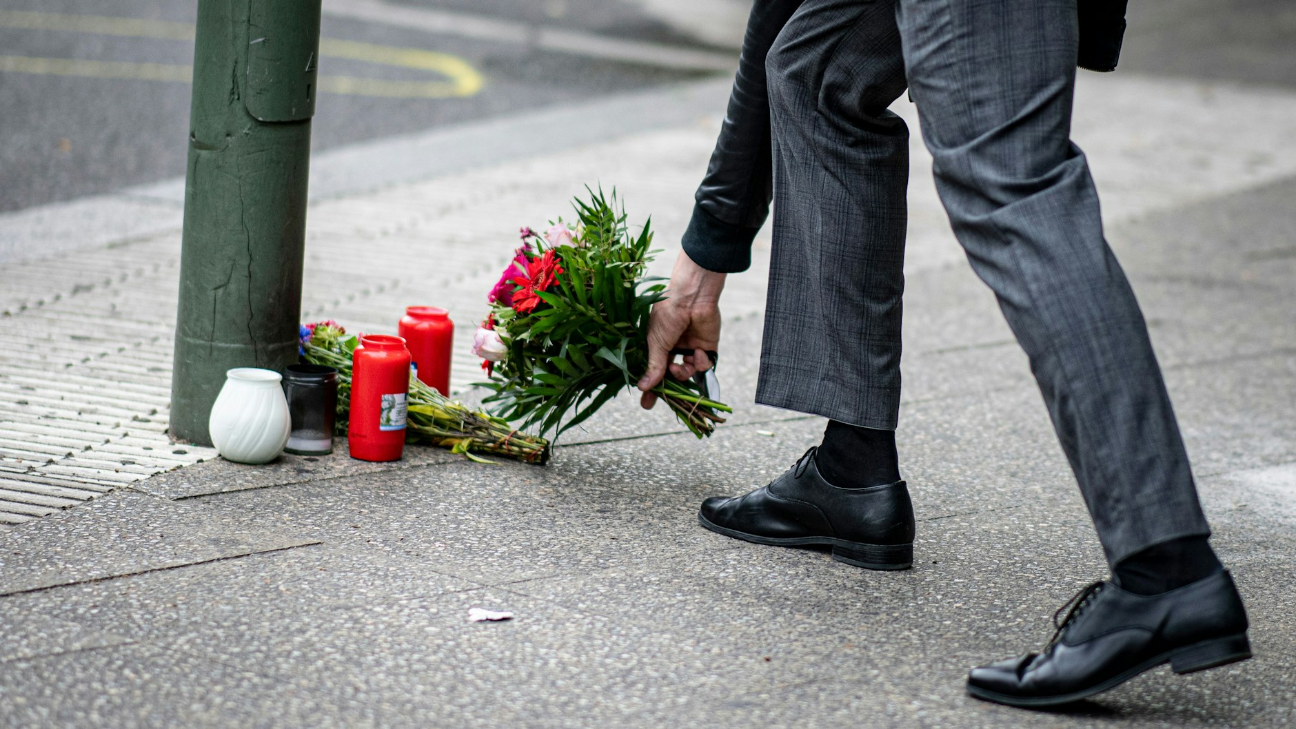 Am Tag nach der tödlichen Amokfahrt legt ein Mann Blumen am Tatort in der Tauentzienstraße ab.