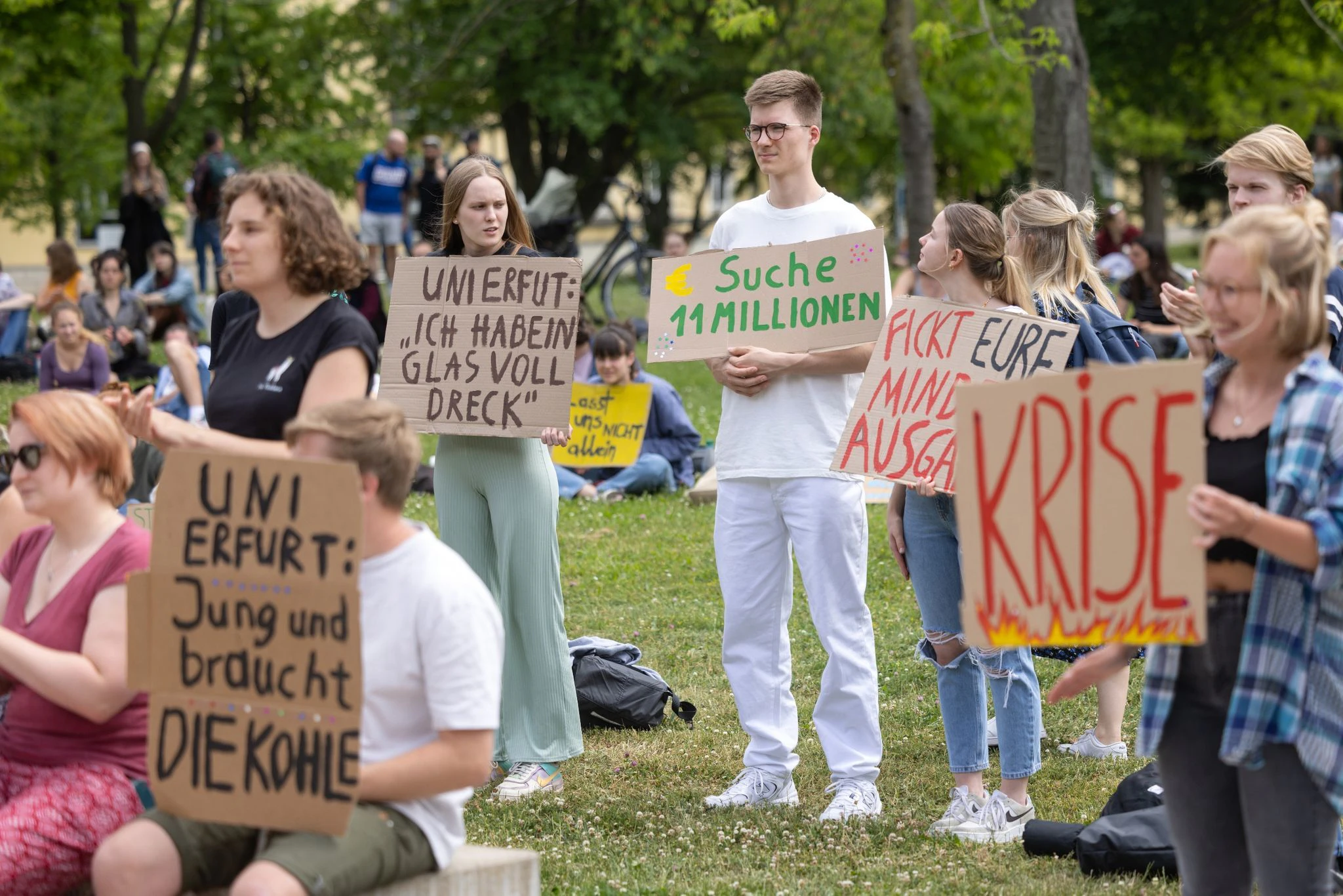 Studierende der Universität Erfurt zeigen offen ihre Unzufriedenheit und demonstrieren auf dem Campus mit Schildern gegen geplante Sparmaßnahmen.  