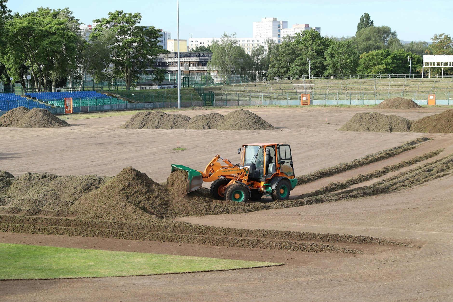 Mit schwerem Gerät wird der Rasen im Sportforum abgetragen.