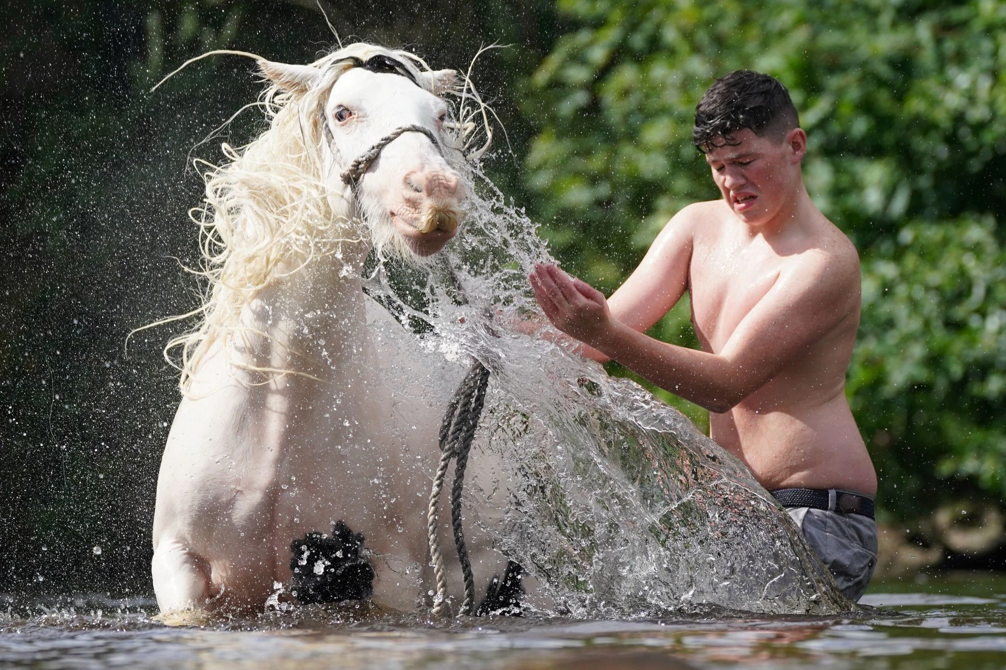 dpatopbilder - Bei einer Pferdemesse im nordenglischen Appleby-in-Westmorland, einer jährlichen Zusammenkunft von Sinti und Roma, wäscht ein junger Mann sein Pferd im Fluss Eden.  