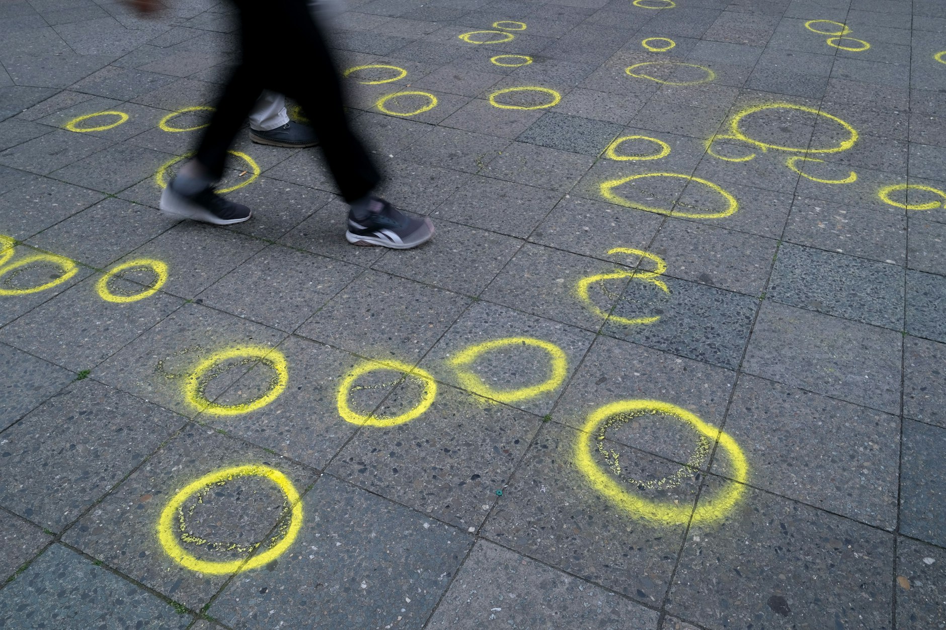 Passanten laufen auf dem Bürgersteig über Polizeimarkierungen