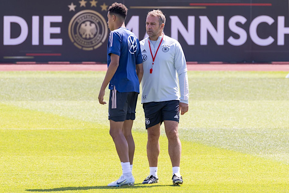Bundestrainer Hansi Flick (r) spricht im Training mit Jamal Musiala.   - WICHTIGER HINWEIS: Gemäß den Vorgaben der DFL Deutsche Fußball Liga bzw. des DFB Deutscher Fußball-Bund ist es untersagt, in dem Stadion und/oder vom Spiel angefertigte Fotoaufnahmen in Form von Sequenzbildern und/oder videoähnlichen Fotostrecken zu verwerten bzw. verwerten zu lassen.
