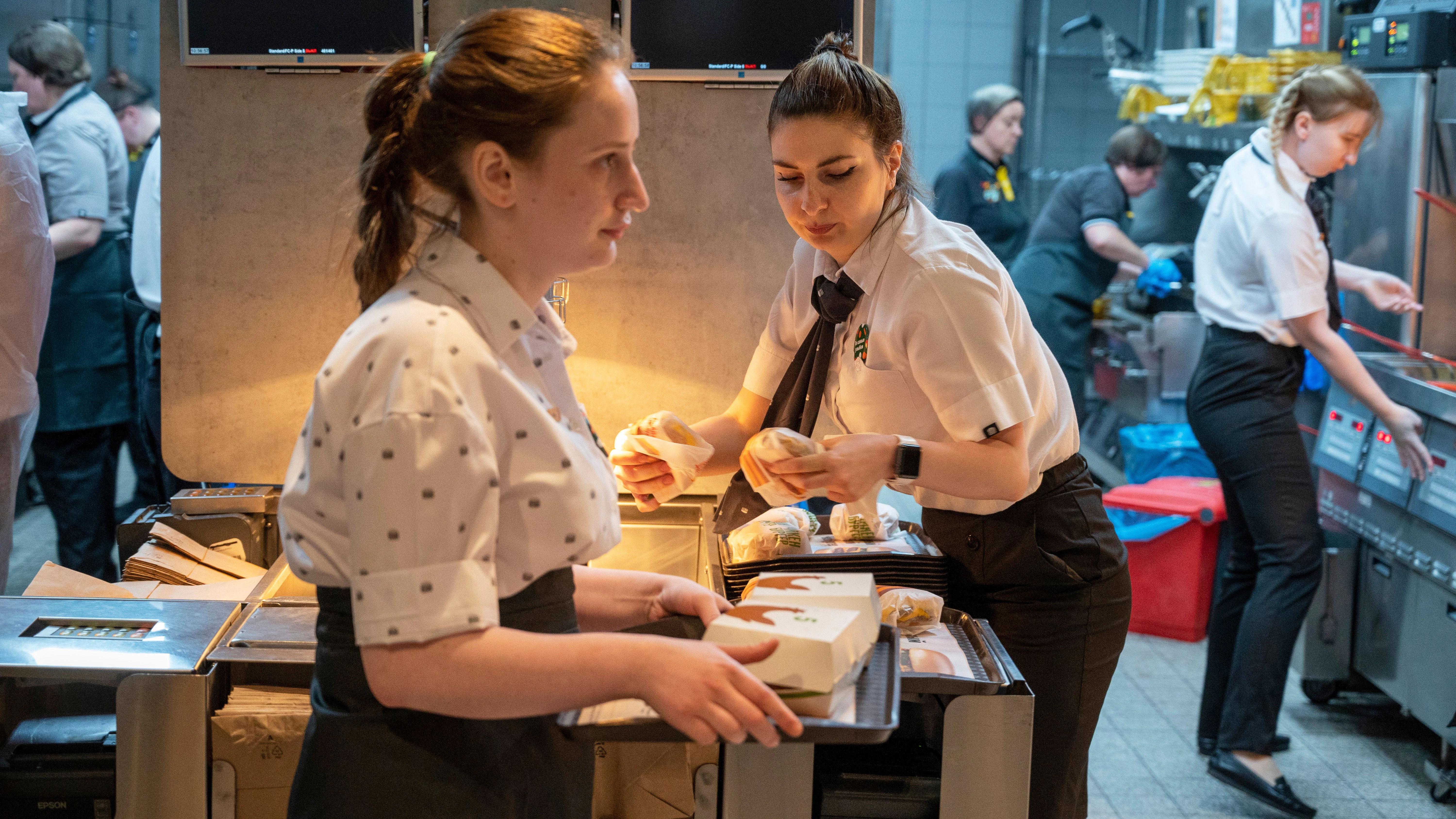Mitarbeiterinnen arbeiten in einem neu eröffneten Fast-Food-Restaurant in einer ehemaligen McDonald’s-Filiale.