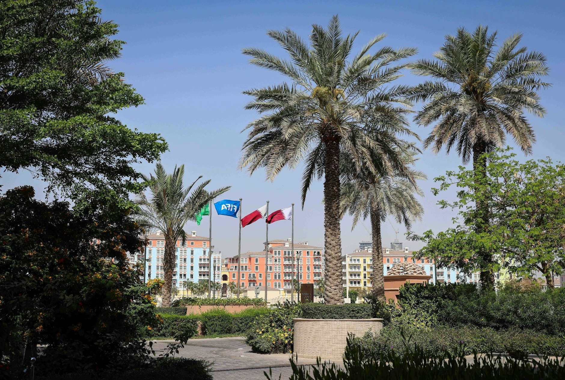 ARCHIV - Die Flaggen Katars und der FIFA wehen vor einer Hotelanlage in Doha.  