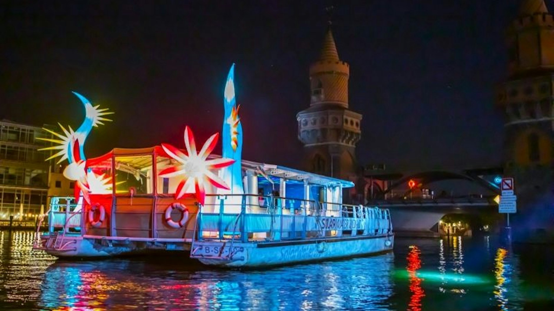 Das beleuchtet Solarschiff auf dem Weg durch das Zentrum von Berlin in den Abendstunden.