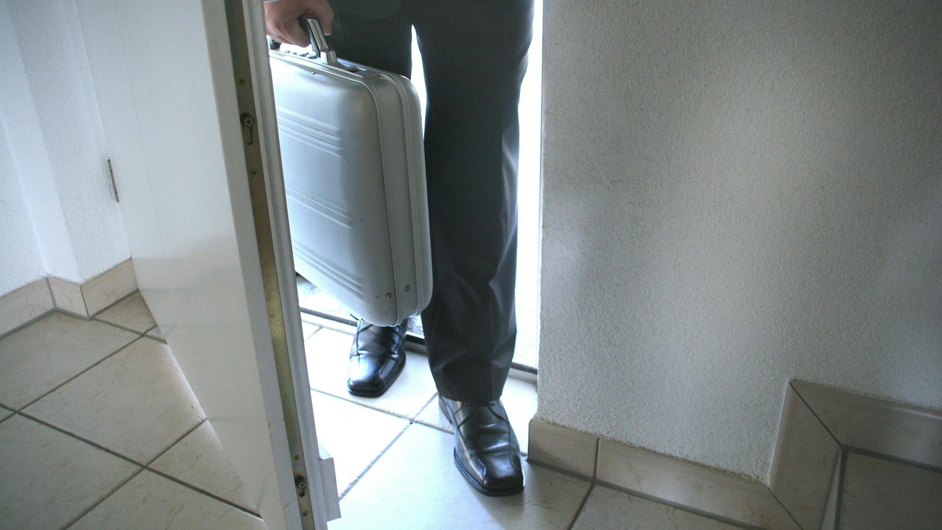 Ein Haustürverkäufer drängelt sich in eine Wohnung. (Symbolbild)