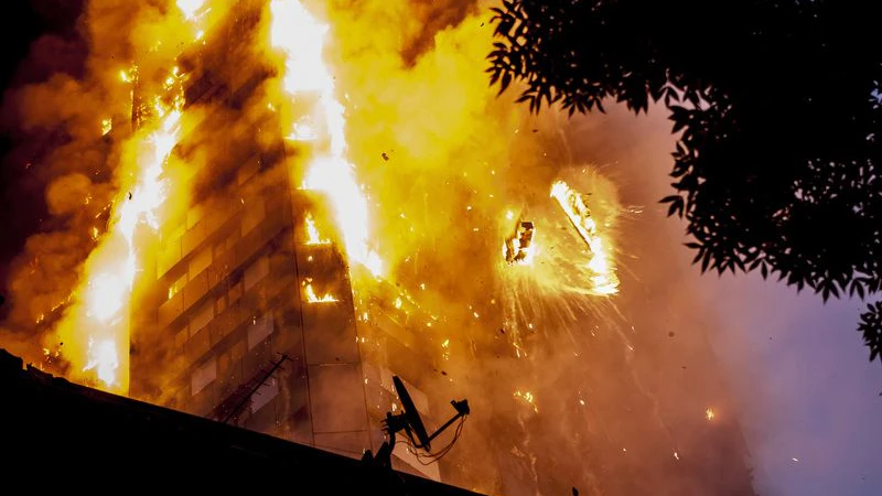 Trümmerteile stürzen aus dem in flammenden stehenden Grenfell Tower. Die Löscharbeiten dauerten Tage.